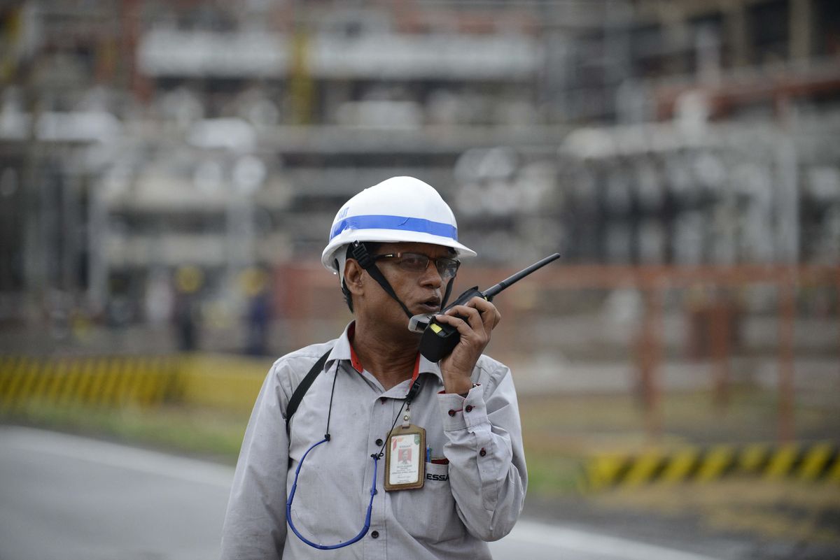 This photograph taken on October 4, 2016 shows a worker talking on a two-way radio at an Indian oil refinery belonging to Essar Oil at Vadinar, some 380km from Ahmedabad.