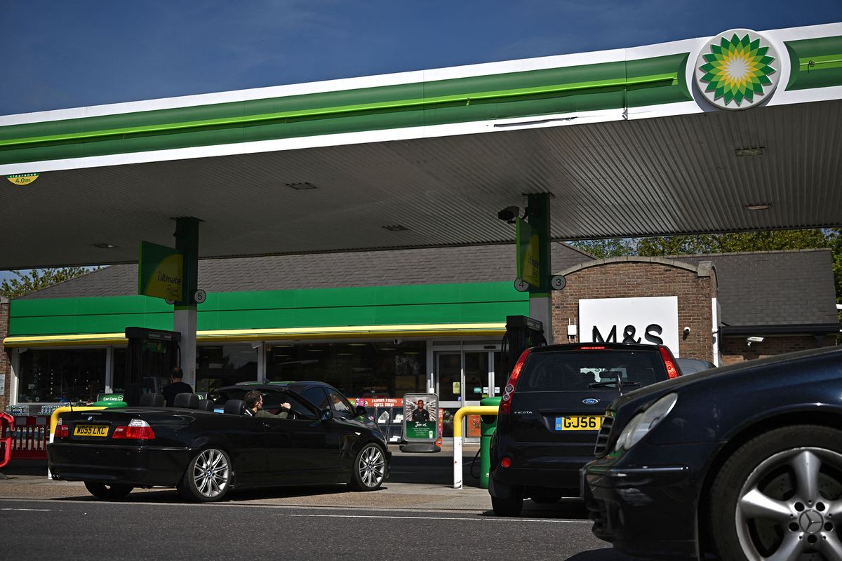 Vehicles fill up at a BP (British Petroleum) petrol station in Tonbridge, south east of London on April 30, 2022. - Britain has been hit hard by rocketing prices of gaz and fuel after the invasion of Ukraine by key gas producer Russia. Britain has vowed to become carbon net zero by 2050, but recently announced plans to drill for more North Sea fossil fuels as it seeks to secure energy independence and axe Russian imports. (Photo by Ben Stansall / AFP)