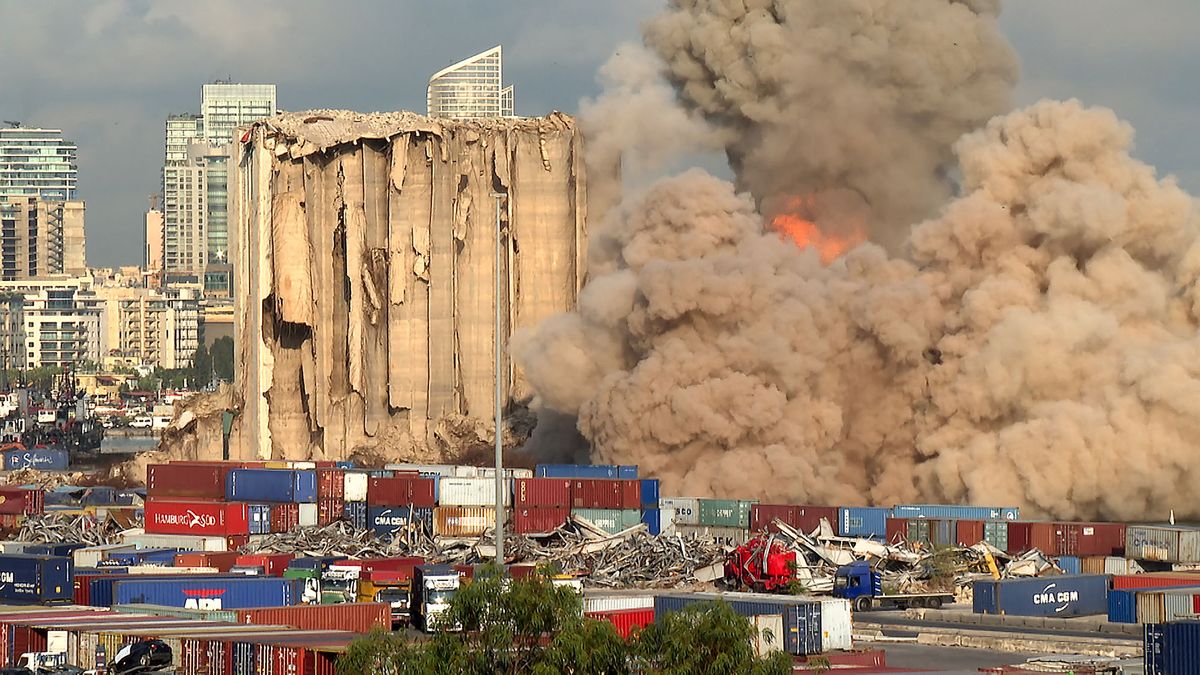 This grab from AFPTV footage shot on August 23, 2022 shows a smoke plume rising after the new collapse of the northern section of the grain silos at the port of Lebanon's capital Beirut, which were previously partly destroyed by the 2020 port explosion. - Eight more grain silos at Beirut port toppled on August 23, succumbing to damage from a devastating 2020 explosion in the third such collapse in a month, AFP correspondents reported. The remaining southern block is more stable and not at imminent risk of collapse, said French civil engineer Emmanuel Durand, who has installed sensors on the silos. (Photo by Dylan COLLINS / AFPTV / AFP)