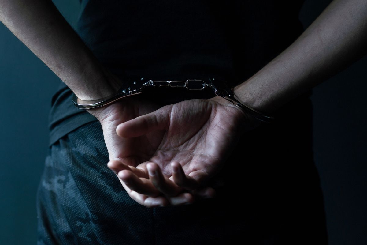 Male,Hands,In,Handcuffs,Black,Background