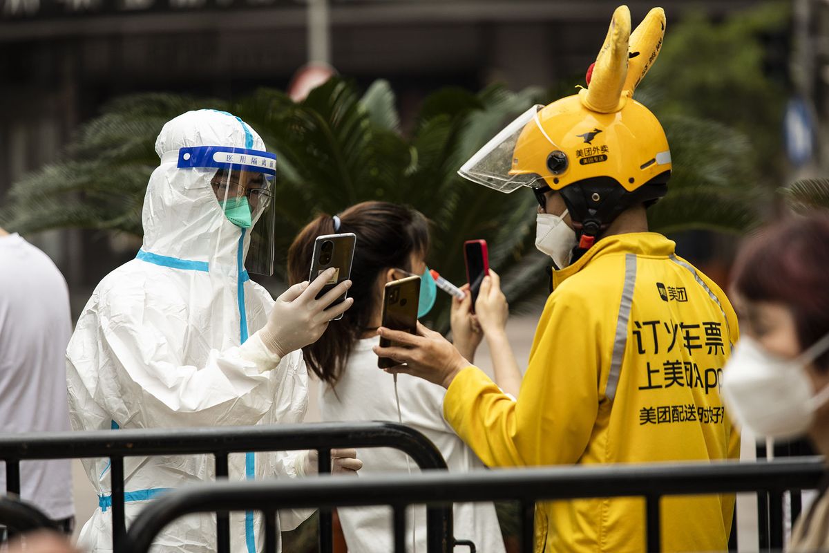 1240998023 A delivery worker for Meituan shows his health code to a worker in personal protective equipment (PPE) in Shanghai, China, on Monday, May 30, 2022. China reported the fewest new Covid-19 cases in almost three months, with the easing of outbreaks in Shanghai emboldening authorities to relax some of the strictest virus controls of the pandemic and move to stimulate the countrys faltering economy. Source: Bloomberg
