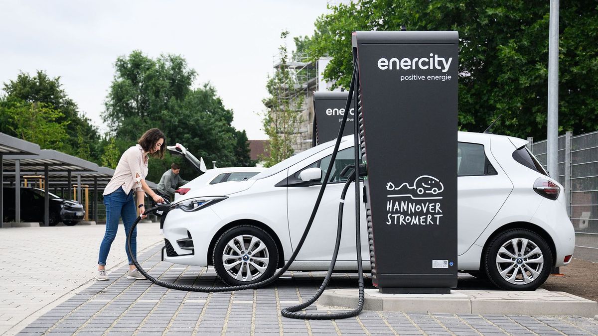 01 July 2022, Lower Saxony, Hanover: An Enercity employee stands with a charging cable for a Renault Zoe electric car at a fast-charging point in a new charging park (posed scene during photo opportunity). The regional utility Enercity is opening a charging park for electric cars in the List district of Hanover. Residents have access to 84 charging points with 22 kW output and six fast charging points with a maximum output of 150 kW each. 60 charging points have already been leased for 30 years. Photo: Julian Stratenschulte/dpa (Photo by JULIAN STRATENSCHULTE / DPA / dpa Picture-Alliance via AFP)
