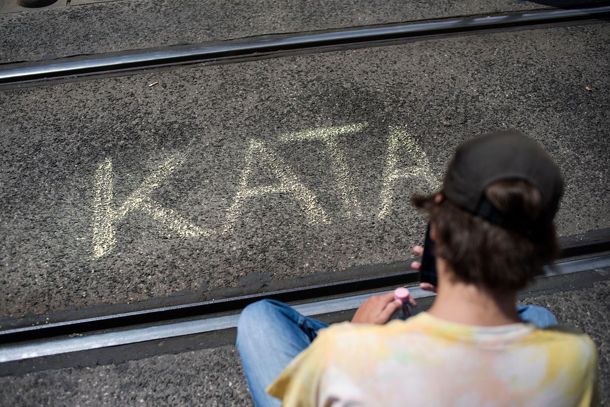 A protester is seen besides the word "KATA" written in the