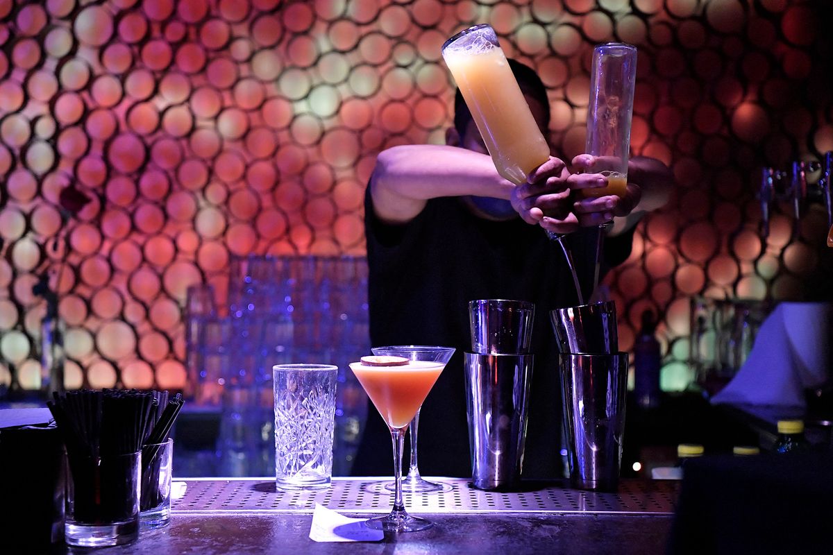 A bartender prepares cocktails in a nightclub in Barcelona on February 10, 2021. - In the northeastern region of Catalonia, nightlife venues were set to open at the stroke of midnight (2300 GMT) on February 11, 2022. In late December, the Catalan government put in place some of Spain's most restrictive measures to fight Omicron, imposing a night curfew from 1:00 am, closing nightlife venues and halving the capacity in bars and restaurants. (Photo by Pau BARRENA / AFP)