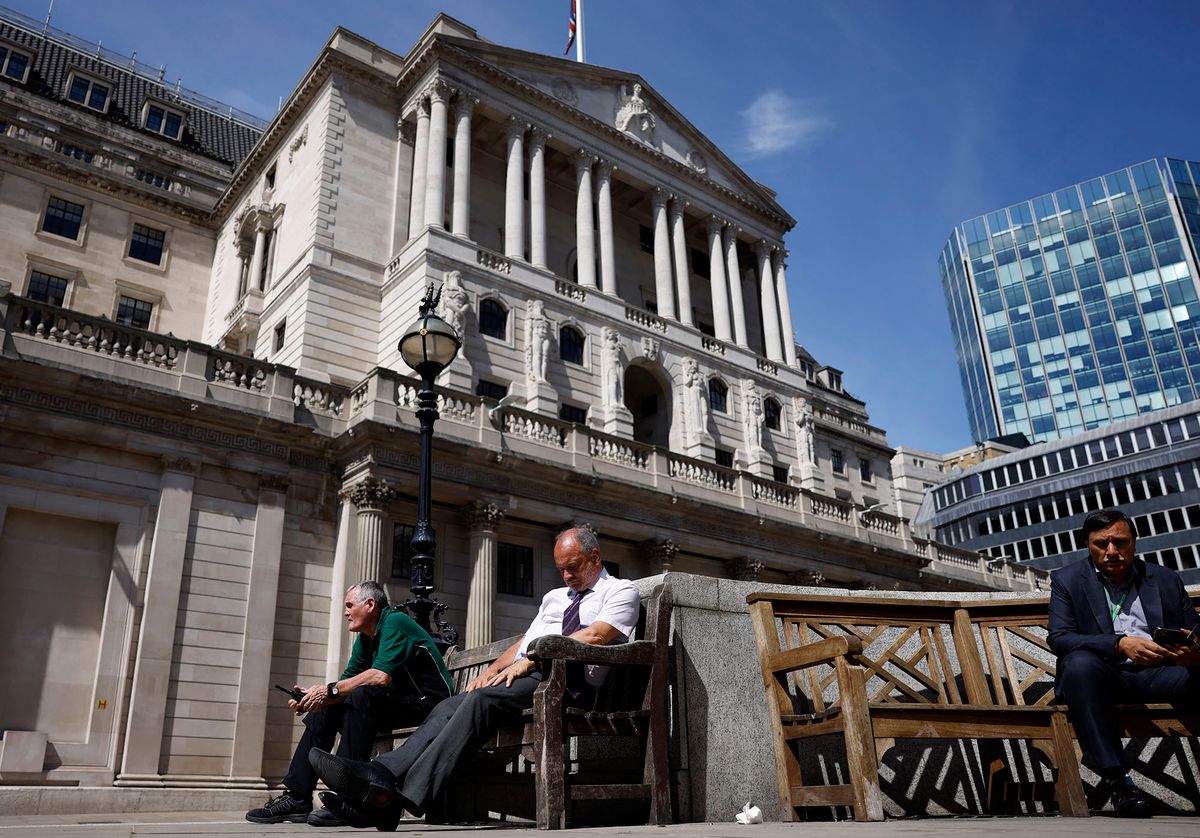 Members of the public take a break in the sunshine outside The Bank of England in London on June 16, 2022. - The Bank of England on Thursday hiked its main interest rate for a fifth straight time, as it forecast British inflation to soar further this year to above 11 percent. (Photo by CARLOS JASSO / AFP)