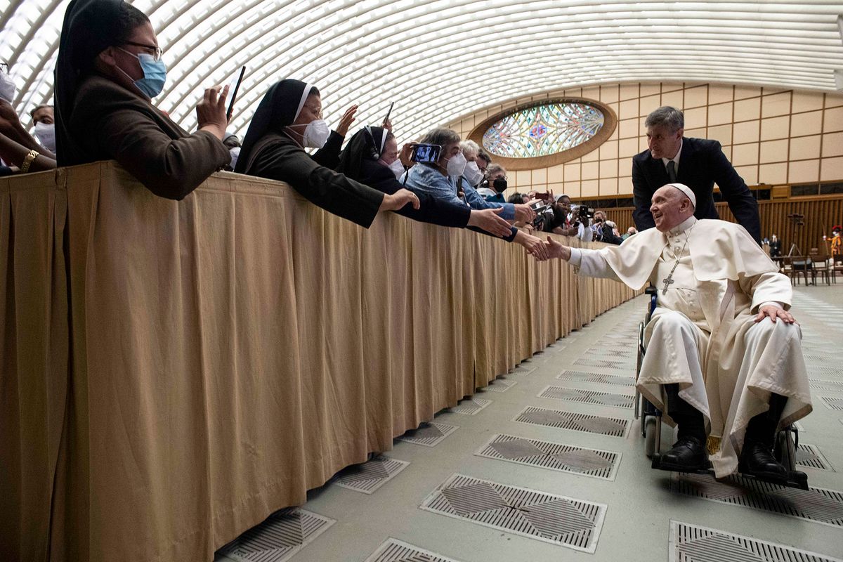 This handout picture taken and released on May 5, 2022 by the Vatican press office, the Vatican Media, shows Pope Francis on wheelchair meeting pilgrims at of an audience to the Participants to Plenary Assembly of the International Union of Superiors General in the Paul VI hall at the Vatican. (Photo by vatican media / VATICAN MEDIA / AFP) / RESTRICTED TO EDITORIAL USE - MANDATORY CREDIT "AFP PHOTO / VATICAN MEDIA" - NO MARKETING NO ADVERTISING CAMPAIGNS - DISTRIBUTED AS A SERVICE TO CLIENTS