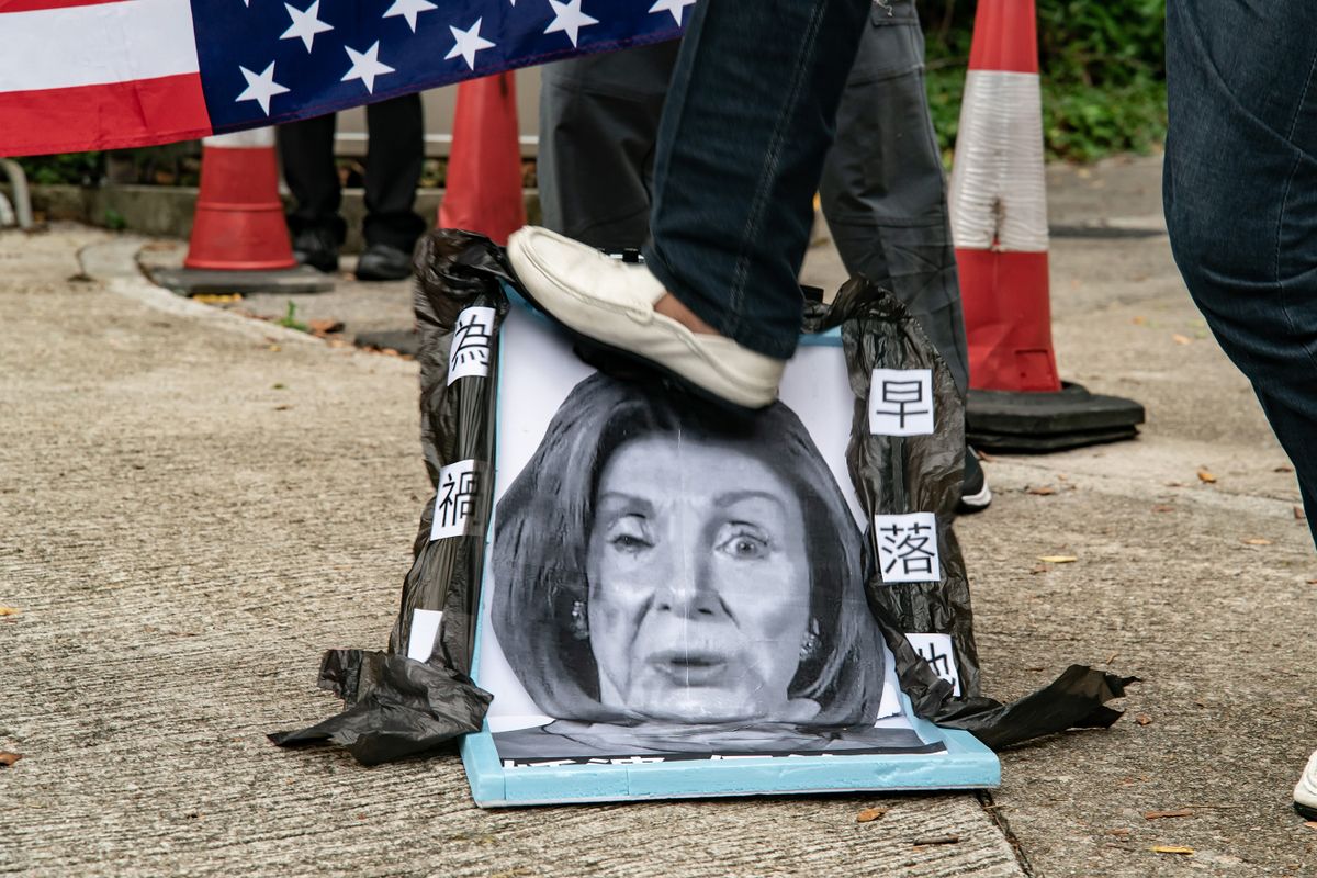 HONG KONG, CHINA - AUGUST 03: A pro-China supporter steps on a defaced photo of U.S. House of Representatives Speaker Nancy Pelosi during a protest against her visit to Taiwan outside the Consulate General of the United States on August 03, 2022 in Hong Kong, China. Pelosi arrived in Taiwan on Tuesday as part of a tour of Asia aimed at reassuring allies in the region, as China made it clear that her visit to Taiwan would be seen in a negative light. 