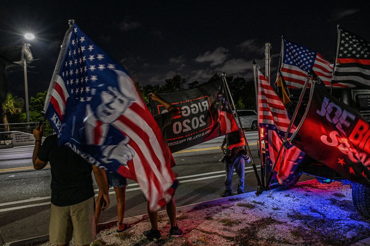 Supporters of former US President Donald Trump stand outside his residence in Mar-A-Lago, Palm Beach, Florida on August 8, 2022. - Former US president Donald Trump said August 8, 2022 that his Mar-A-Lago residence in Florida was being "raided" by FBI agents in what he called an act of "prosecutorial misconduct." (Photo by Giorgio VIERA / AFP)