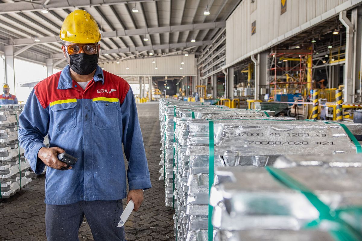 1241586071 A worker inspects stacked aluminium ingots at the cast house of Emirates Global Aluminium PJSC Al Taweelah plant in Abu Dhabi, United Arab Emirates, on Monday, June 27, 2022. Emirates Global Aluminium and GE Gas Power have signed an agreement to upgrade four gas turbines at the Al Taweelah power plant, to help reduce gas emissions. Photographer: Christopher Pike/Bloomberg via Getty Images