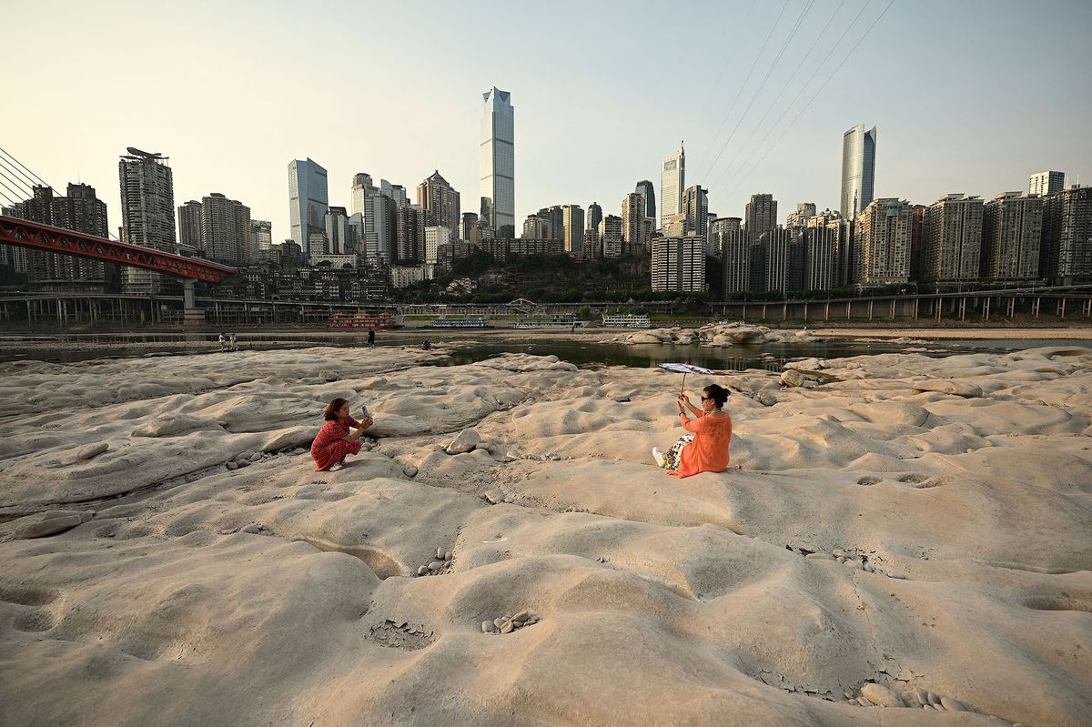 People are seen at the dried-up riverbed of the Jialing river, a tributary of the Yangtze River in China's southwestern city of Chongqing on August 25, 2022. (Photo by Noel Celis / AFP)