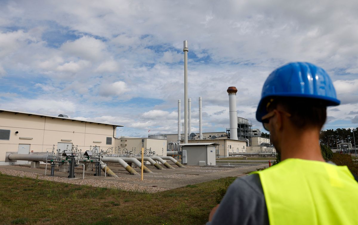 A man stands in front of facilities to receive and distribute natural gas on the grounds of gas transport and pipeline network operator Gascade in Lubmin, northeastern Germany, close to the border with Poland, on August 30, 2022. - Lubmin's industrial infrastructure includes a receiving and distribution station for the Nord Stream 1 pipeline and is also the place where the finally canned Nord Stream 2 pipeline for more gas from Russia comes to shore. The construction of a terminal to receive LNG at the site is planned. Government measures to assure supplies of gas over the winter have prepared Germany to deal with further curbs in Russian deliveries, Chancellor Olaf Scholz said on August 30, 2022, a day before Moscow is due to cut off gas supplies for three days. (Photo by Odd ANDERSEN / AFP)
