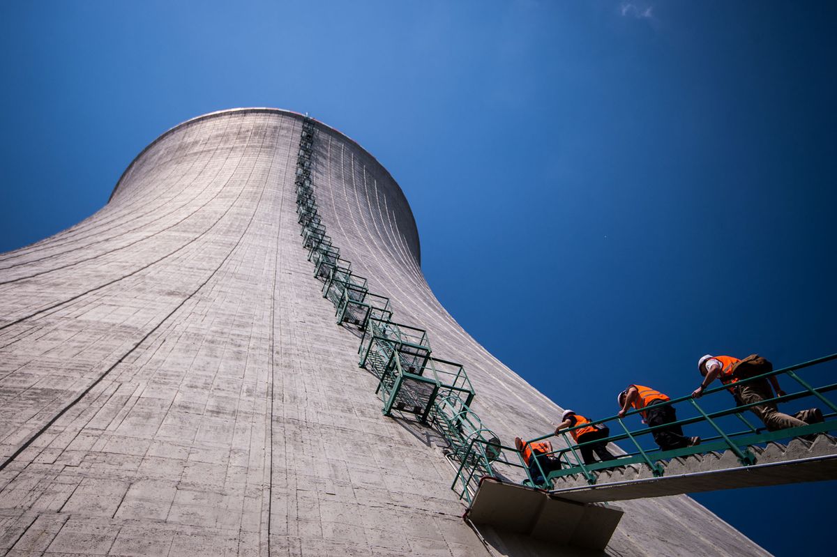 Journalists climb into the cooling tower of the third and fourth unit still under construction at Mochovce nuclear power plant, western Slovakia, on July 2, 2019. - Top Slovak power producer Slovenske Elektrarne (SE) operates the nuclear power plant in Mochovce. Launching of the two new units has been a cause for concern in neighbouring Austria, which has repeatedly criticised what it insists are their poor safety standards. (Photo by VLADIMIR SIMICEK / AFP)