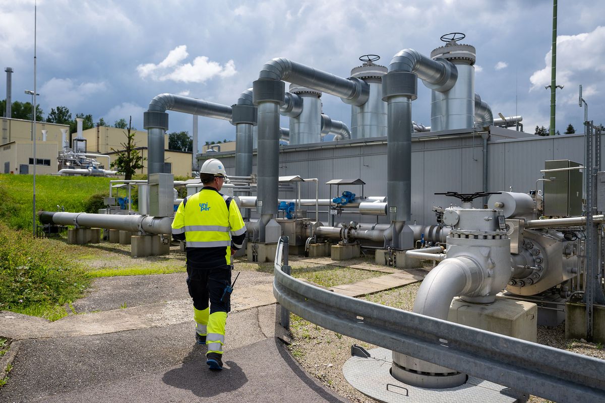 An employee of Uniper Energy Storage walks through the above-ground facilities of a natural gas storage facility  at the Uniper Energy Storage facility in Bierwang, southern Germany on June 10, 2022. (Photo by LENNART PREISS / AFP)