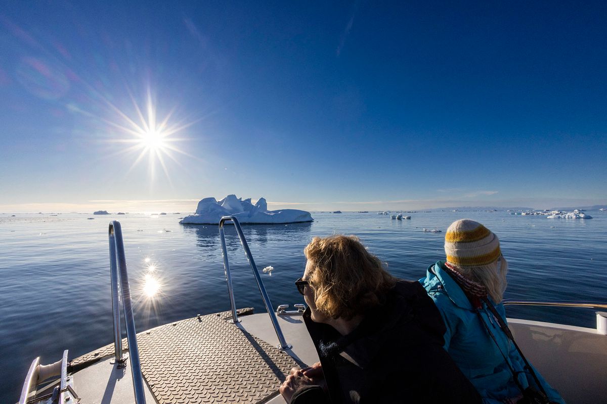 Visitors on a sightseeing vessel watch icebergs floating in Disko Bay, Ilulissat, western Greenland, on June 28, 2022. - The icebergs originate from Jakobshavn glacier (Sermeq Kujalleq), the most productive glacier in the Northern Hemisphere. The massive icebergs that detach from the glacier float for years in the waters in front of the fjord before being carried south by ocean currents. (Photo by Odd ANDERSEN / AFP)
