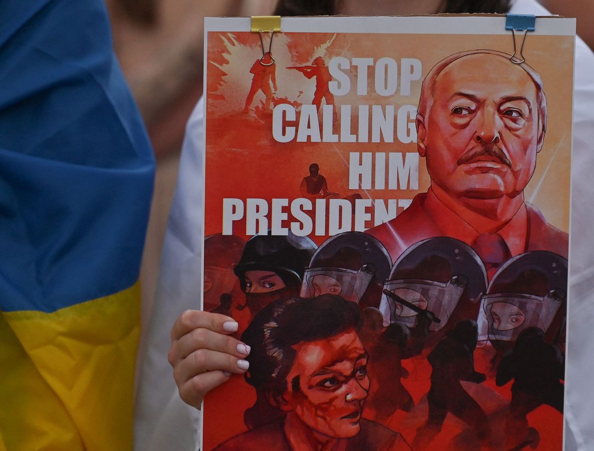 A protester holding a poster with an image of the  Belarusian leader with words 'Stop Calling Him President'.Members of the local Belarusian and Ukrainian diaspora supported by local Cracovians during the Solidarity with Belarus 2022 march, in the center of Krakow, on the 2nd anniversary of the presidential elections in Belarus.On Tuesday, August 09, 2022, in Krakow, Lesser Poland Voivodeship, Poland. (Photo by Artur Widak/NurPhoto) (Photo by Artur Widak / NurPhoto / NurPhoto via AFP)