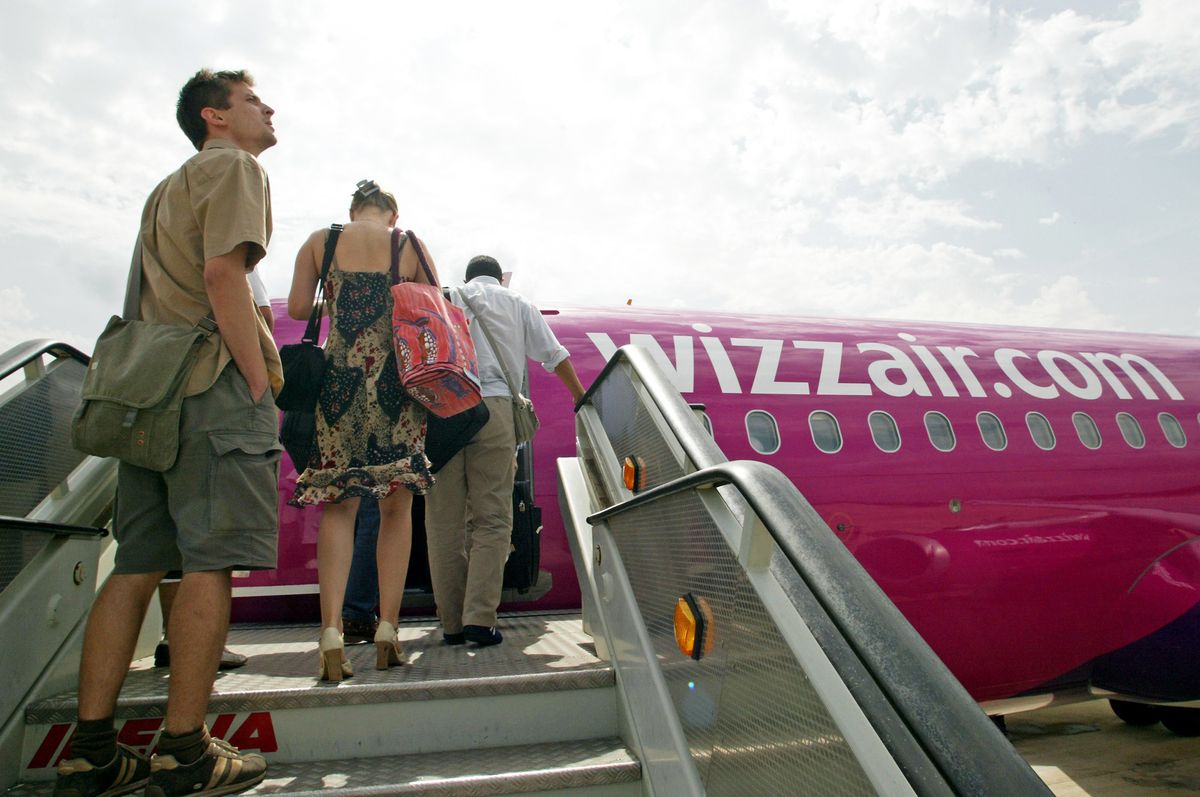 Passengers board a Wizz Air airplane on the tarmac at Gerona