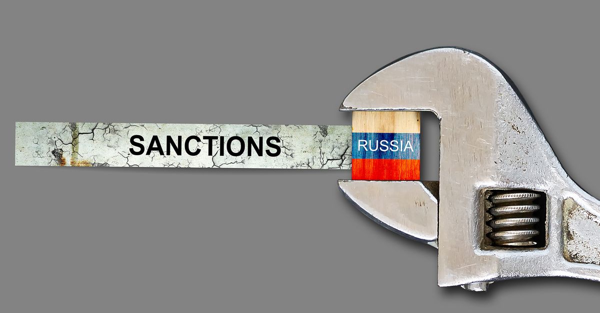 Sanctions.,Flag,Of,Russia,On,A,Wooden,Block,,Clamped,With