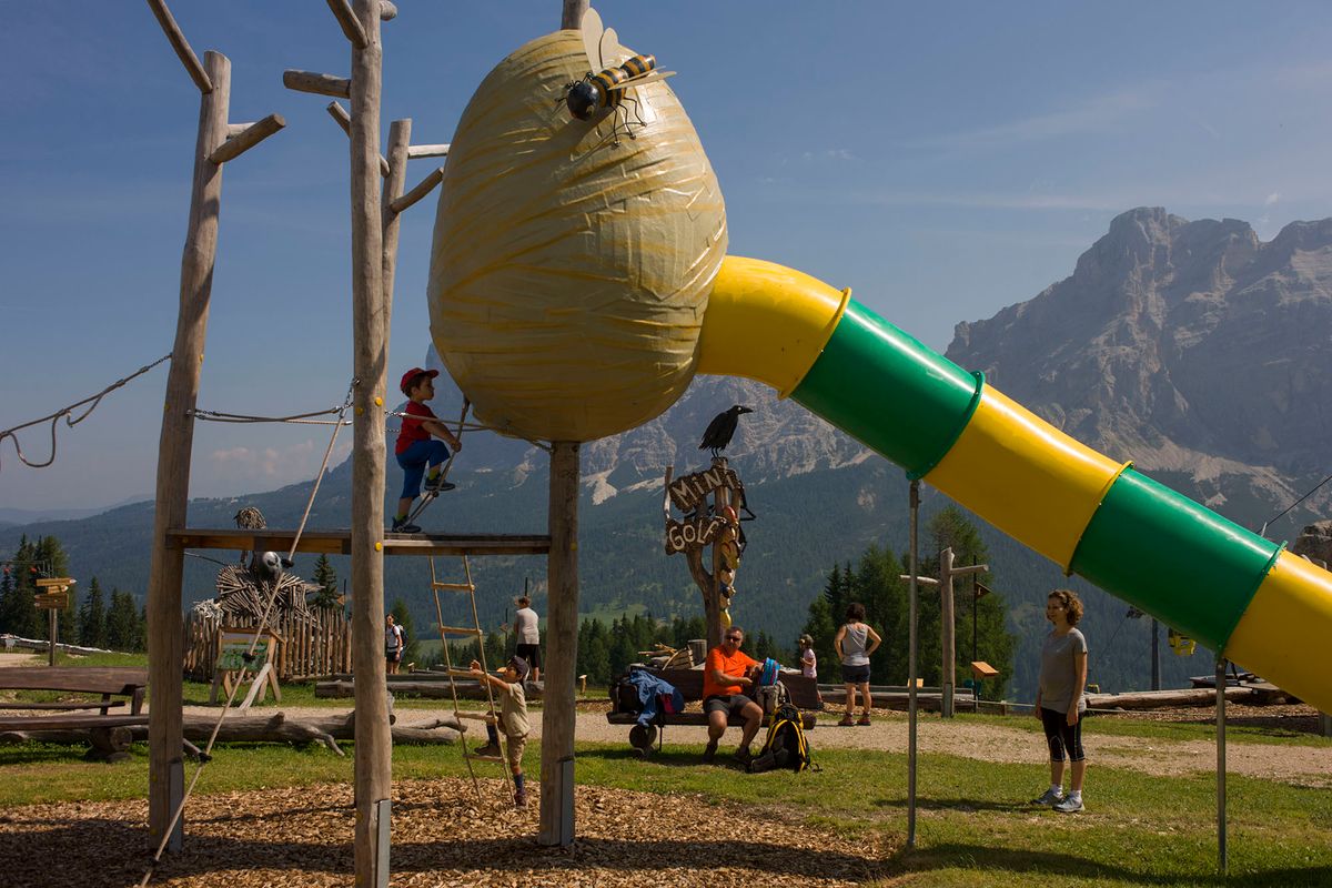 527465454 A playground near the Piz Sorega cable car station in the Pralongi�� above San Cassiano-St. Kassian in the Dolomites, south Tyrol, northern Italy. Parents watch as their children climb and have fun on climbing structures with the backdrop of mountain peak panoramas. This is known as the Movim��nt where activities for families with young people can play, exercise and general experience the great outdoors at 2,000 metres above sea level between the towns of La Villa, San Cassiano and Corvara in the (Photo by In Pictures Ltd./Corbis via Getty Images)