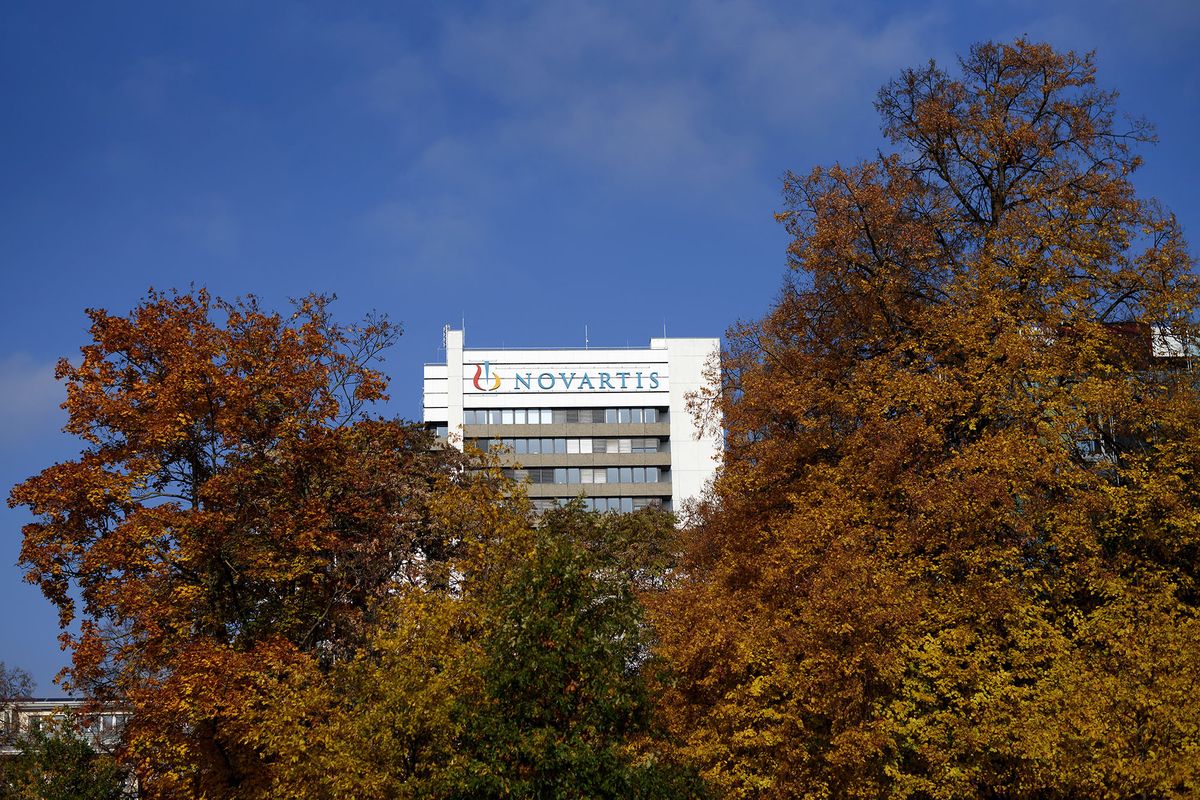 A sign of Swiss pharmaceutical giant Novartis is seen on the top of a building at the company's campus on October 27, 2015 in Basel. Novartis said that its third-quarter net profit fell by 42 percent to $1.8 billion (1.64 billion euros), partially due to provisions to settle a US corruption case. However the world's largest pharmaceutical company in terms of sales confirmed its 2015 targets, including sales growth from continuing operations in mid-single digits excluding exchange rate effects and growth in operating income in the high single digits. AFP PHOTO / FABRICE COFFRINI (Photo by Fabrice COFFRINI / AFP)