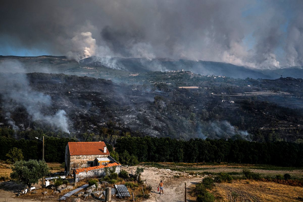 A resident watches the progression of a wildfire in Linhares, Celorico da Beira, on August 11, 2022. (Photo by PATRICIA DE MELO MOREIRA / AFP)