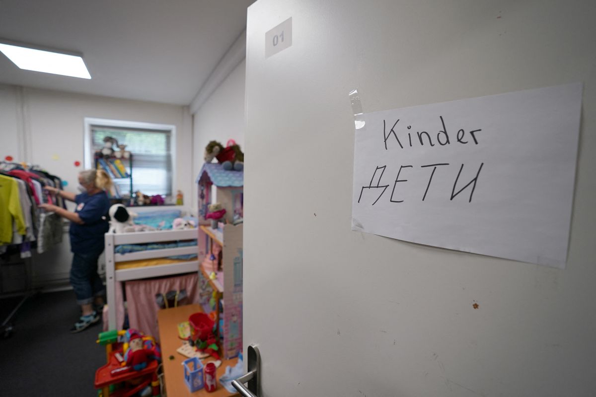 27 July 2022, Schleswig-Holstein, Bad Segeberg: "Children" is written in German and Ukrainian letters on a door of the clothing store of the German Red Cross (DRK), in the state shelter for refugees Bad Segeberg. Since the beginning of May, the State Office for Refugees and Migration has been supporting the districts and independent cities in registering displaced persons from Ukraine. Photo: Marcus Brandt/dpa (Photo by MARCUS BRANDT / DPA / dpa Picture-Alliance via AFP)