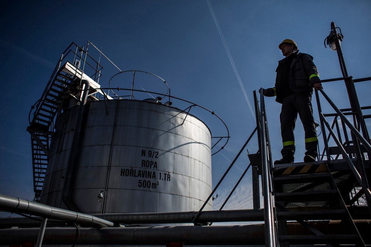 An employee stands on a platform beside an oil storage tank at an oil plant operated by MND AS in Damborice, Czech Republic, on Monday, March 23, 2015. Oil rose as the dollar weakened for a third day, making commodities priced in the U.S. currency more attractive to investors. Photographer: Martin Divisek/Bloomberg via Getty Images