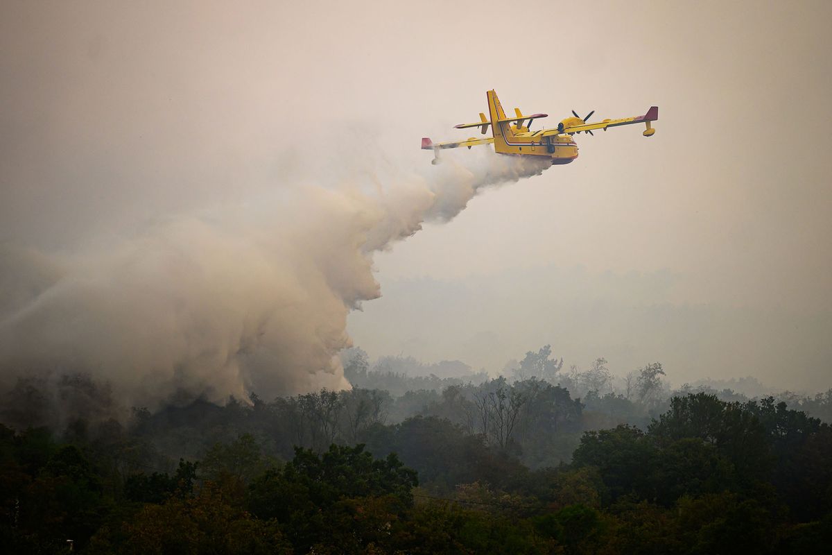 Croatia’s Canadair airplane helps to extinguish wildfires close to the village of Kostanjevica na Krasu, on July 20, 2022. - Hundreds of firefighters were deployed in western Slovenia on July 20, 2022 to battle a blaze that forced the evacuation of several villages, emergency services said. (Photo by Jure Makovec / AFP)
