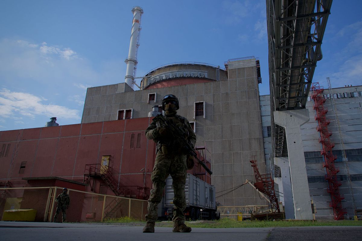 A Russian serviceman stands guard the territory outside the second reactor of the Zaporizhzhia Nuclear Power Station in Energodar on May 1, 2022. - The Zaporizhzhia Nuclear Power Station in southeastern Ukraine is the largest nuclear power plant in Europe and among the 10 largest in the world.  *EDITOR'S NOTE: This picture was taken during a media trip organised by the Russian army.* (Photo by Andrey BORODULIN / AFP)
