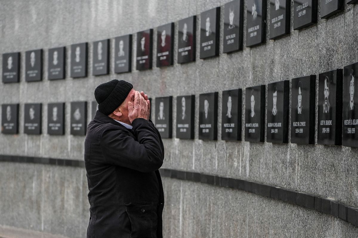 A Kosovo Albanian man prays in front of a commemorative plaque dedicated to the victims of the Racak massacre on January 15, 2020 in the village of Racak. - In 1999, forty-five Albanian civilians were killed by Serb forces, in the village of Racak. The massacre, one of the bloodiest that occurred in the Kosovo crisis, led to massive international pressure on Serbia to stop their ethnically motivated killings of civilian Albanians and to a NATO led air campaign that ousted Serbian security forces from Kosovo. (Photo by Armend NIMANI / AFP)