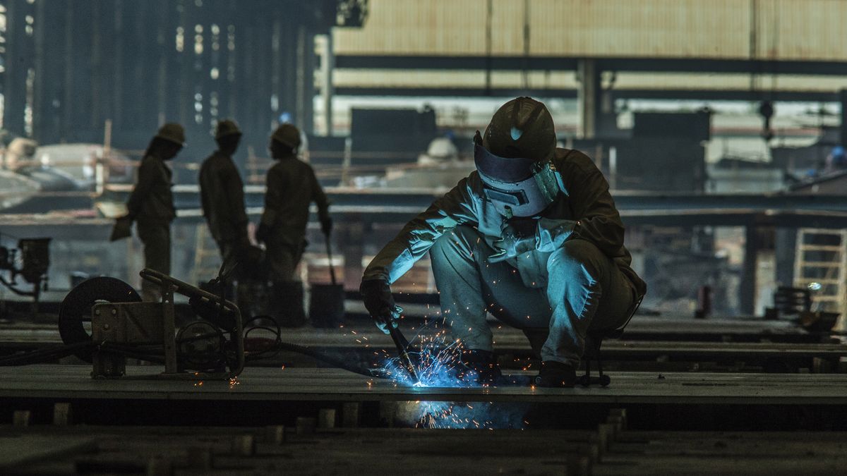 Welder working at a ship building yard in China.