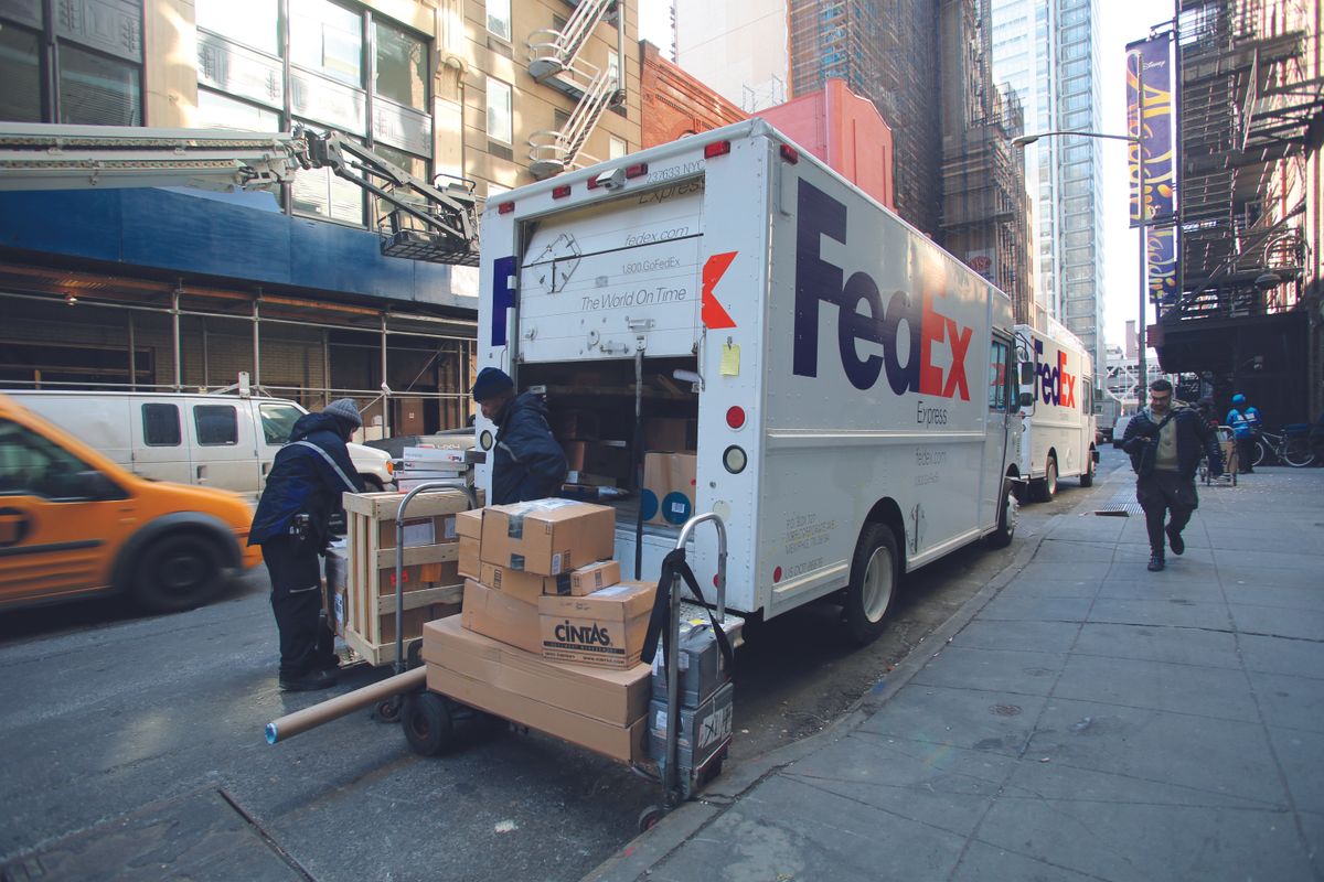 New,York,City,-,Feb.,25,,2015:,Fedex,Drivers,Unload, NEW YORK CITY - FEB. 25, 2015:  FedEx drivers unload two delivery vans in midtown Manhattan. FedEx Corporation is an American global courier delivery services company, NEW YORK CITY - FEB. 25, 2015:  FedEx drivers unload two delivery vans in midtown Manhattan. FedEx Corporation is an American global courier delivery services company 