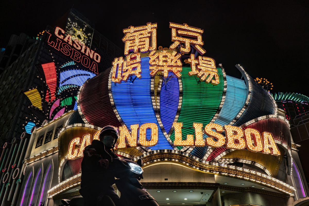 MACAU, CHINA - FEBRUARY 04: A motorcyclist stops for a traffic light in front of the Casino Lisboa on February 4, 2020 in Macau, China. Macau government announced to close casinos for two weeks after a hotel worker is infected. Macau has 10 confirmed cases of Novel coronavirus (2019-nCoV), with over 20,000 confirmed cases around the world, the virus has so far claimed over 400 lives.
