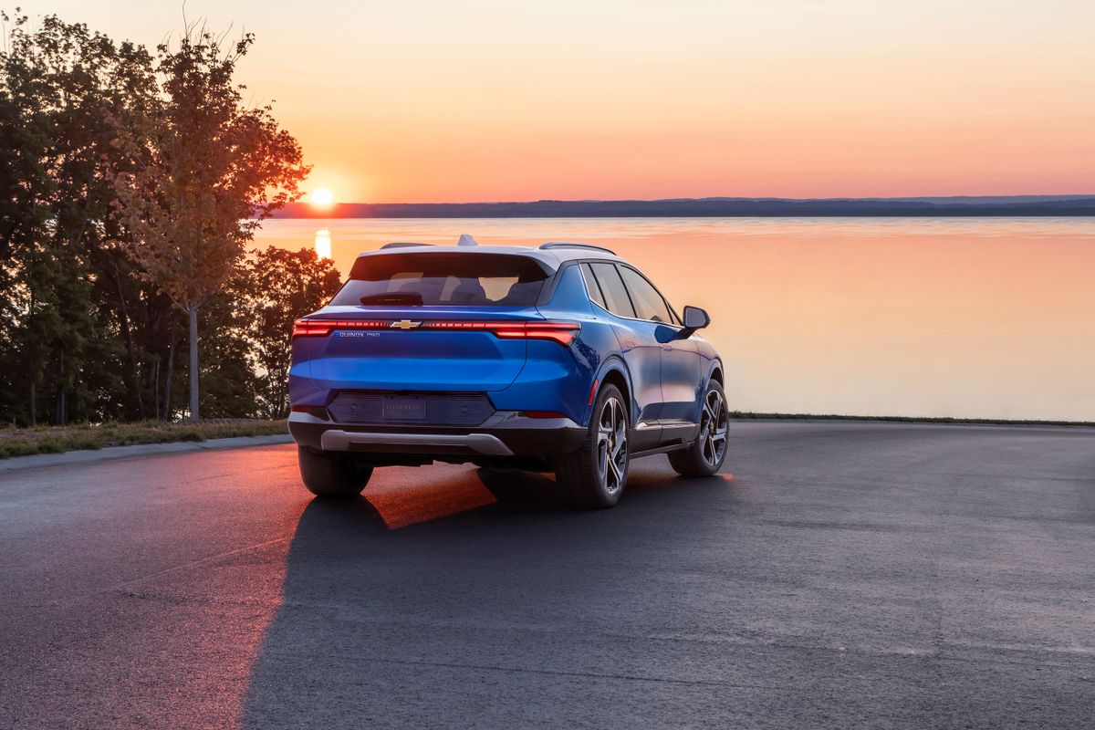 Rear view of 2024 Chevrolet Equinox EV 3LT in Riptide Blue parked in front of sunset. Preproduction model shown. Actual production model may vary. 2024 Chevrolet Equinox EV available Fall 2023.