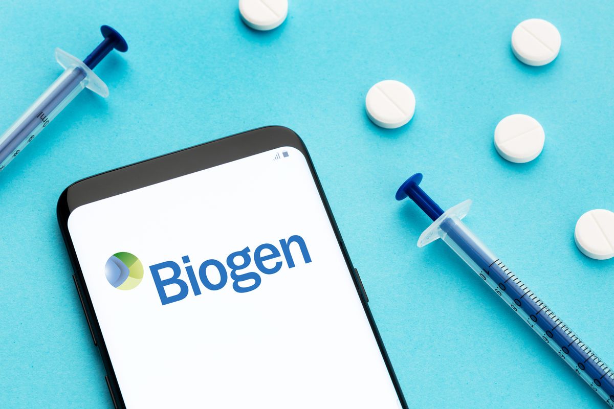 Galicia,,Spain;,June,8,,2020,:,Smart,Phone,Showing,Biogen Galicia, Spain; June 8, 2020 : Smart phone showing Biogen logo on screen and pills and syringe on blue background Galicia, Spain; June 8, 2020 : Smart phone showing Biogen logo on screen and pills and syringe on blue background
