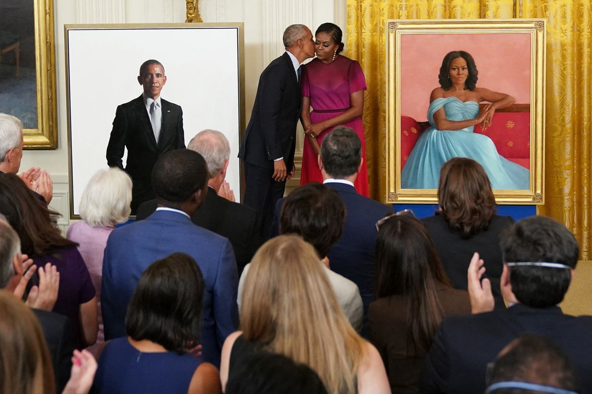 Former US President Barack Obama kisses former US First Lady Michelle Obama during a ceremony to unveil their official White House portraits, in the East Room of the White House in Washington, DC, on September 7, 2022. (Photo by Mandel NGAN / AFP)