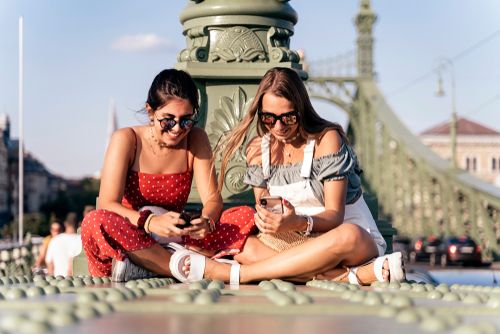 Happy,Young,Female,Friends,In,Sunglasses,Sitting,Near,Column,And