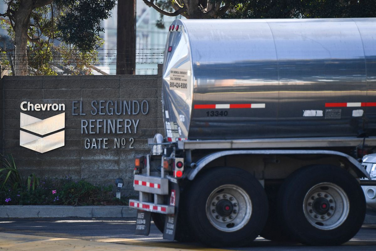 The Chevron logo is displayed as a tanker truck enters the Chevron Products Company El Segundo Refinery on January 26, 2022 in El Segundo, California. - The oil refinery supplies motor vehicle fuels including gasoline and diesel to Southern California as well as jet fuel for aircraft at Los Angeles International Airport (LAX)