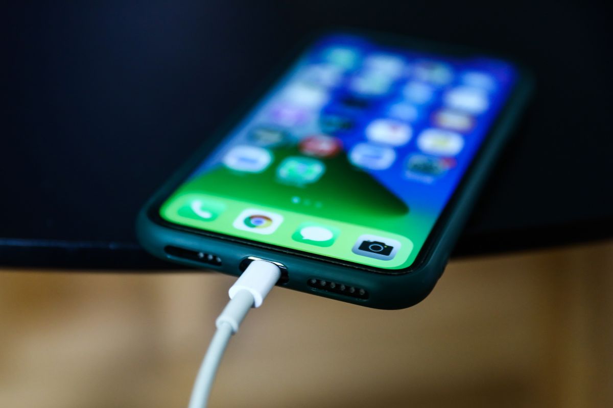 Apple iPhone connected to a Lightning cable is seen in this illustration photo taken in Poland on September 25, 2021. 