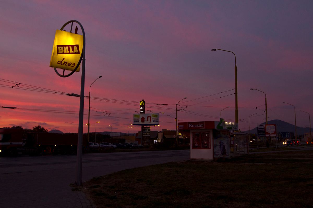 A sunset over a sign for a budget convenience store in a suburb of Presov, a city in the Slovak Republic. 