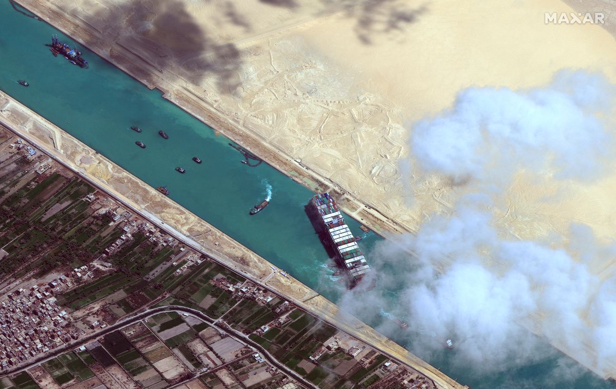 This satellite imagery released by Maxar Technologies shows an overview of the MV Ever Given container ship and tugboats in the Suez Canal on March 29, 2021. - The MV Ever Given was refloated and the Suez Canal reopened on March 29, 2021, sparking relief almost a week after the huge container ship got stuck during a sandstorm and blocked a major artery for global trade. AFP correspondents observed tugboat crews sounding their foghorns in celebration after the Ever Given, a cargo megaship the length of four football fields, was dislodged from the banks of the Suez. (Photo by Satellite image ©2021 Maxar Technologies / AFP) / RESTRICTED TO EDITORIAL USE - MANDATORY CREDIT "AFP PHOTO / Satellite image ©2021 Maxar Technologies" - NO MARKETING - NO ADVERTISING CAMPAIGNS - DISTRIBUTED AS A SERVICE TO CLIENTS EGYPT-SHIPPING-SUEZ
