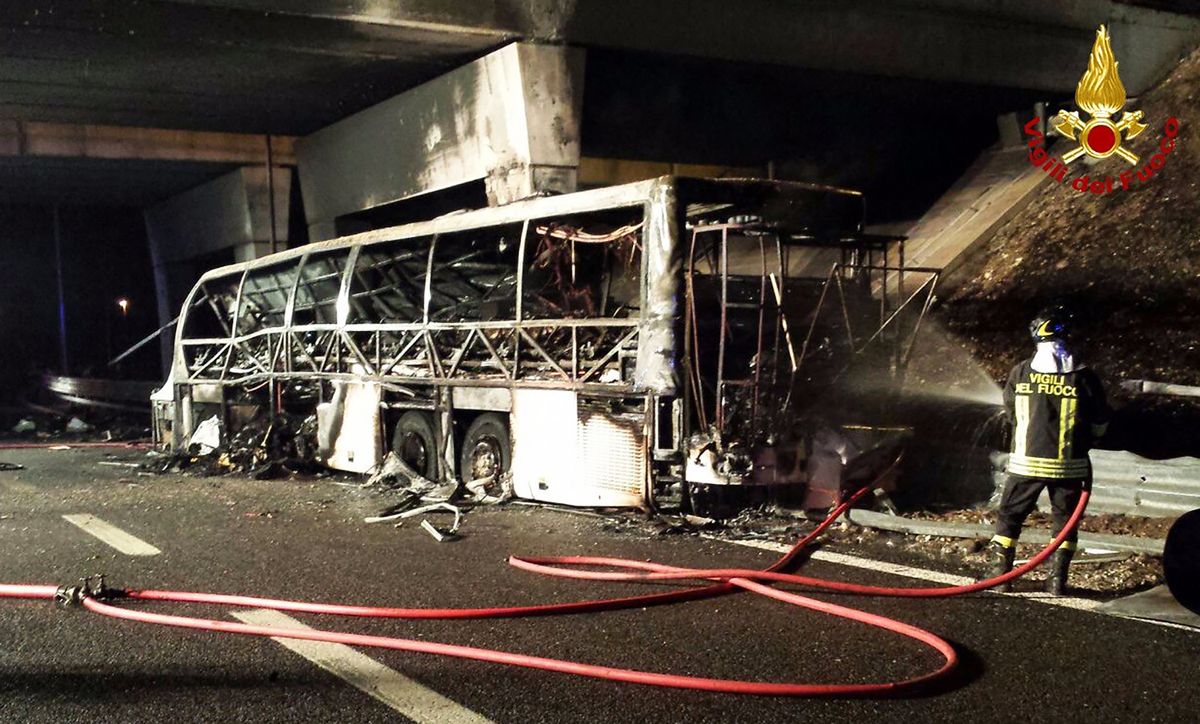 A handout photo provided by Italy's institutional agency for fire and rescue service Vigili del Fuoco on January 21, 2017 shows a firefighter extinguishing flames in the wreckage of a bus following a crash on the A4 motorway near the Verona East exit, northern Italy. - The coach carrying Hungarian teenagers home from a school trip crashed and burst into flames on the motorway in northern Italy, killing 16 people, firefighters said Saturday. Some 39 injured were taken to hospital following the accident near Verona on Friday night, which occurred when the vehicle smashed into a bridge pillar, according to emergency workers. (Photo by Handout / Vigili del Fuoco / AFP) / RESTRICTED TO EDITORIAL USE - MANDATORY CREDIT "AFP PHOTO / VIGILI DEL FUOCO" - NO MARKETING NO ADVERTISING CAMPAIGNS - DISTRIBUTED AS A SERVICE TO CLIENTS ITALY-HUNGARY-BUS-ROAD-ACCIDENT