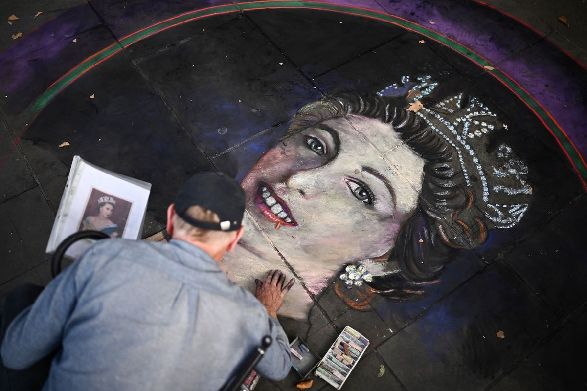 An artist draws a portrait of Britain's Queen Elizabeth II on tiles with chalk at Trafalgar Square in London on September 11, 2022. - Queen Elizabeth II's coffin will travel by road through Scottish towns and villages on Sunday as it begins its final journey from her beloved Scottish retreat of Balmoral. The Queen, who died on September 8, will be taken to the Palace of Holyroodhouse before lying at rest in St Giles' Cathedral, before travelling onwards to London for her funeral. 