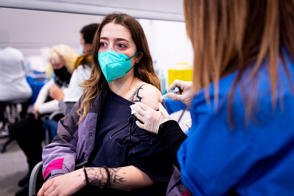 A young teenage girl is seen receiving a shot of Covid-19 vaccine at a vaccination center in Barcelona, Spain, on December 22, 2021. Following the spread of the Omicron variant, the Spanish government is pushing the vaccination campaign and for older people to get the third booster shot and for children aged 5-11 to get their first covid vaccine dose. (Photo by Davide Bonaldo / Controluce via AFP)