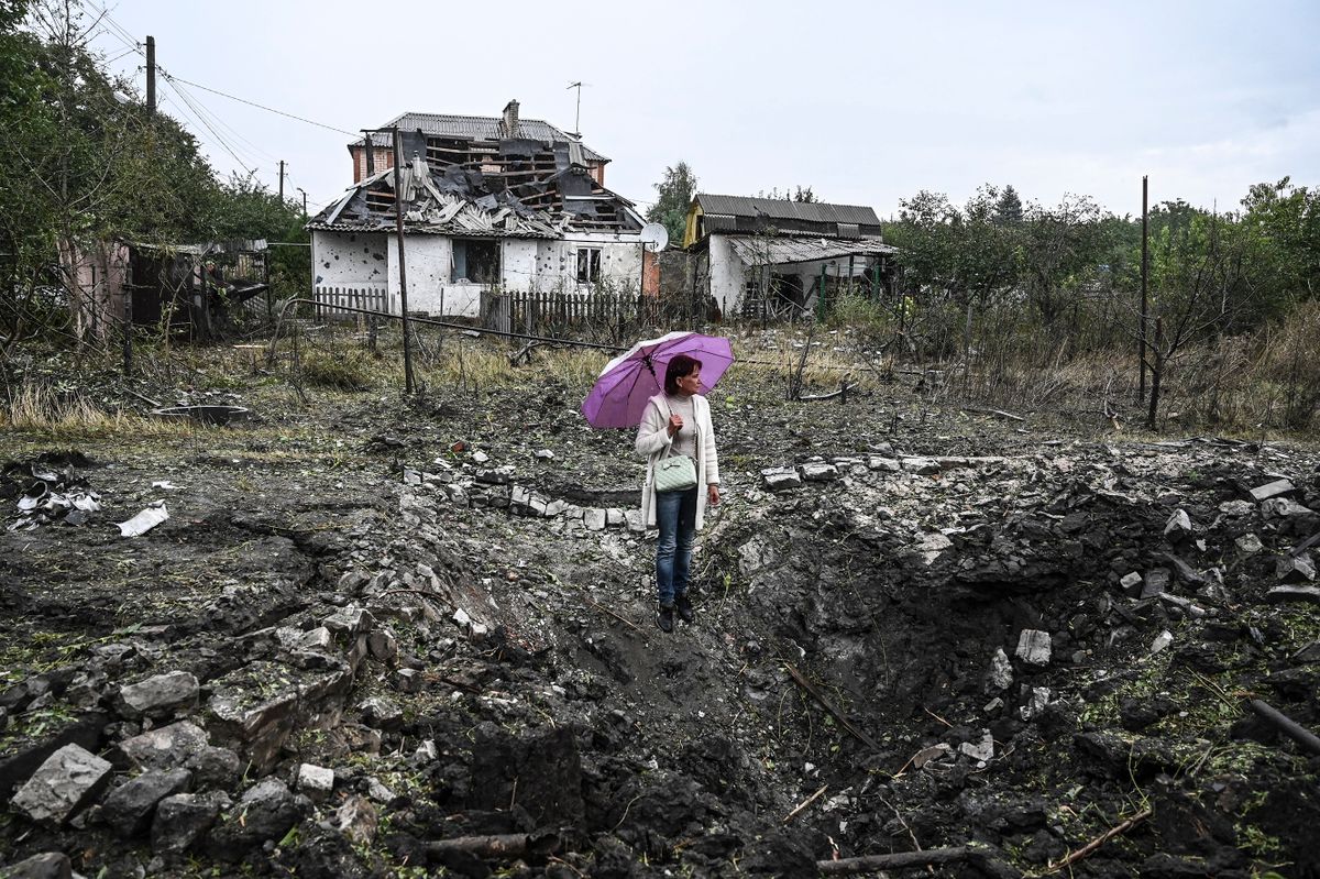 A woman stands in front of a destroyed house, in Kramatorsk, Donetsk region, on September 12, 2022, amid the Russian invasion of Ukraine. 