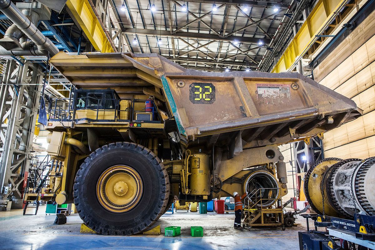 1047292622 A worker inspects a dump truck in a repair shop for large machinery at the Oyu Tolgoi copper-gold mine, jointly owned by Rio Tinto Group's Turquoise Hill Resources Ltd. unit and state-owned Erdenes Oyu Tolgoi LLC, in Khanbogd, the South Gobi desert, Mongolia, on Sunday, Sept. 23, 2018. Mongolia plans to supply the copper-gold mine with energy by the start of 2019, Mongolian Energy Minister Davaasuren Tserenpil said in interview with newspaper Zasgiin Gazariin Medee. The massive copper-and-gold mine was discovered in 2001 and Rio, the world's second-biggest miner, gained control in 2012. Photographer: Taylor Weidman/Bloomberg via Getty Images