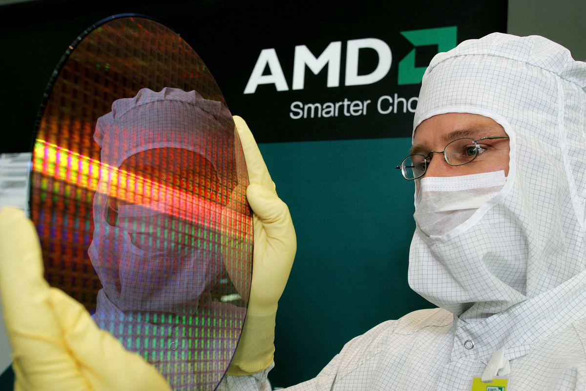 Module Shift Manager Guido Gebert presents a 300-millimetre wafer of Advanced Micro Devices (AMD), the US maker of computer chips, 24 October 2006 in Dresden, eastern Germany. AMD, plans to invest 2,5 billion dollars (1,96 billion euros) in expanding capacity at its Dresden factory over the next three years. AFP PHOTO  DDP/NORBERT MILLAUER    GERMANY OUT (Photo by NORBERT MILLAUER / DDP / ddp images via AFP)