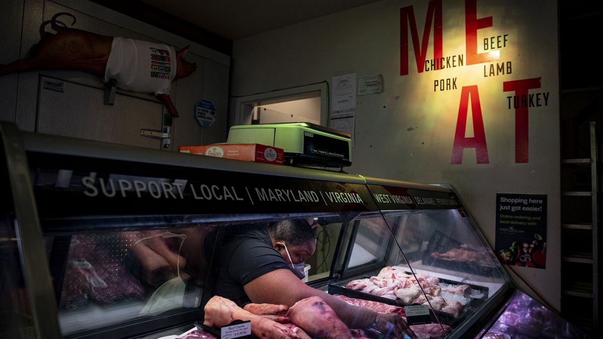 A worker adjusts a price tag on a cut of meat for sale at a butcher shop in the Union Market district in Washington, D.C., US, on Tuesday, Aug. 30, 2022. Food prices in July climbed 10.9% from a year earlier, according to the US Department of Labor, with the cost of food away from home such as restaurant meals advancing but at a slower pace than groceries. Photographer: 