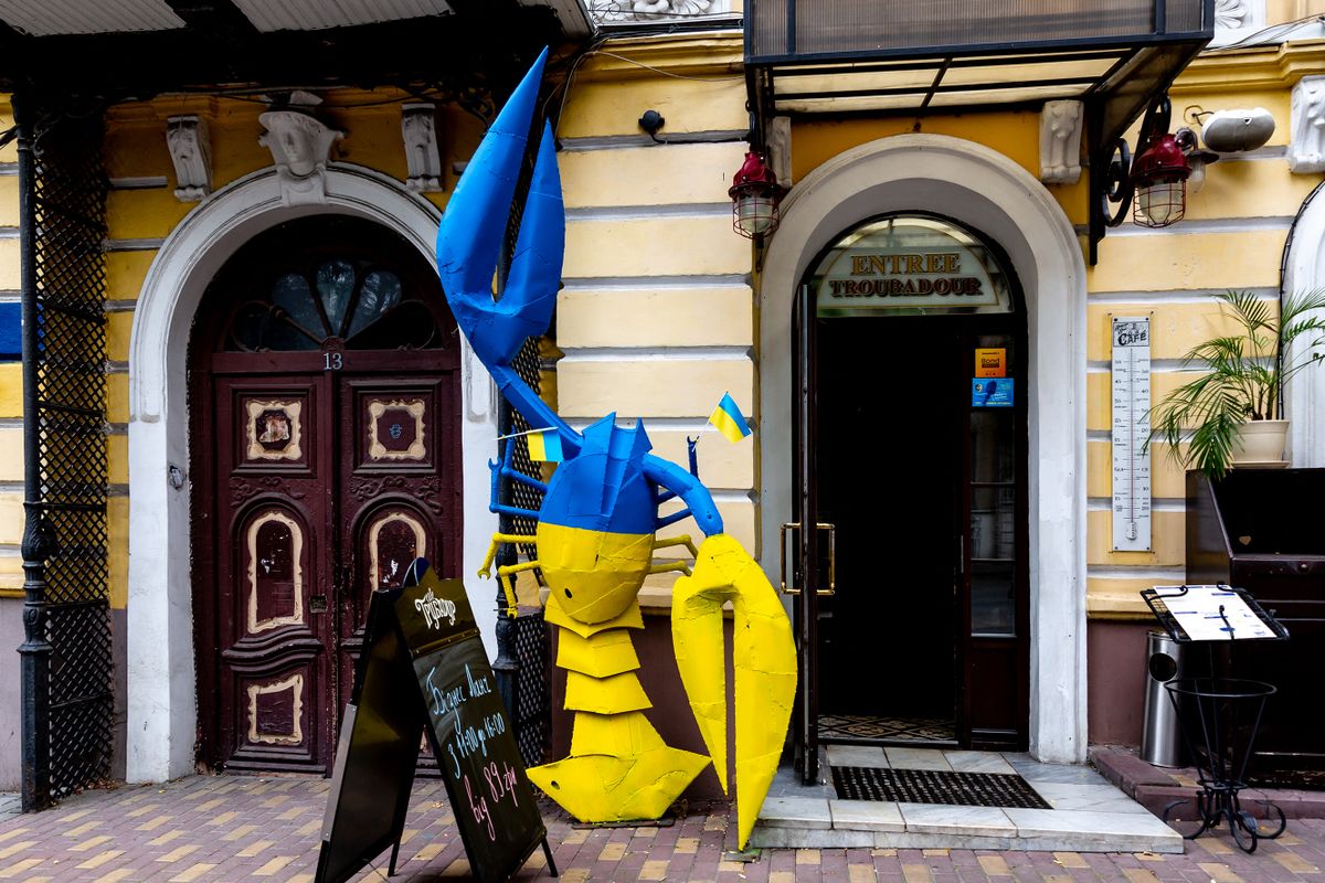 Blue and yellow giant crayfish in front of a restaurant is seen in a centre of the famous Black Sea resort of Odessa, Ukraine on Septembre 7, 2022. Ukrainian national flag colours - blue and yellow - have a strong presence in urban space in Ukraine. The colours are often used in advertisement, decoration, and in everyday use objects. This tendency became strong in 2014 and increased drastically after the Russian invasion in 2022. )