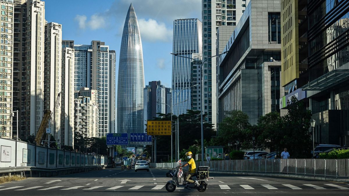 This photo taken on July 20, 2022, shows a delivery worker riding a scooter on a street in Shenzhen, in China's southern Guangdong province. 