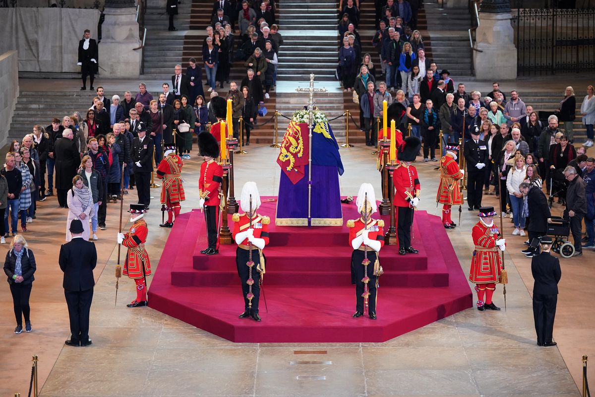 Members of the public pay their respects as they pass the coffin of Queen Elizabeth II as it Lies in State inside Westminster Hall, at the Palace of Westminster in London on September 16, 2022. - Queen Elizabeth II will lie in state in Westminster Hall inside the Palace of Westminster, until 0530 GMT on September 19, a few hours before her funeral, with huge queues expected to file past her coffin to pay their respects. (Photo by Yui Mok / POOL / AFP)